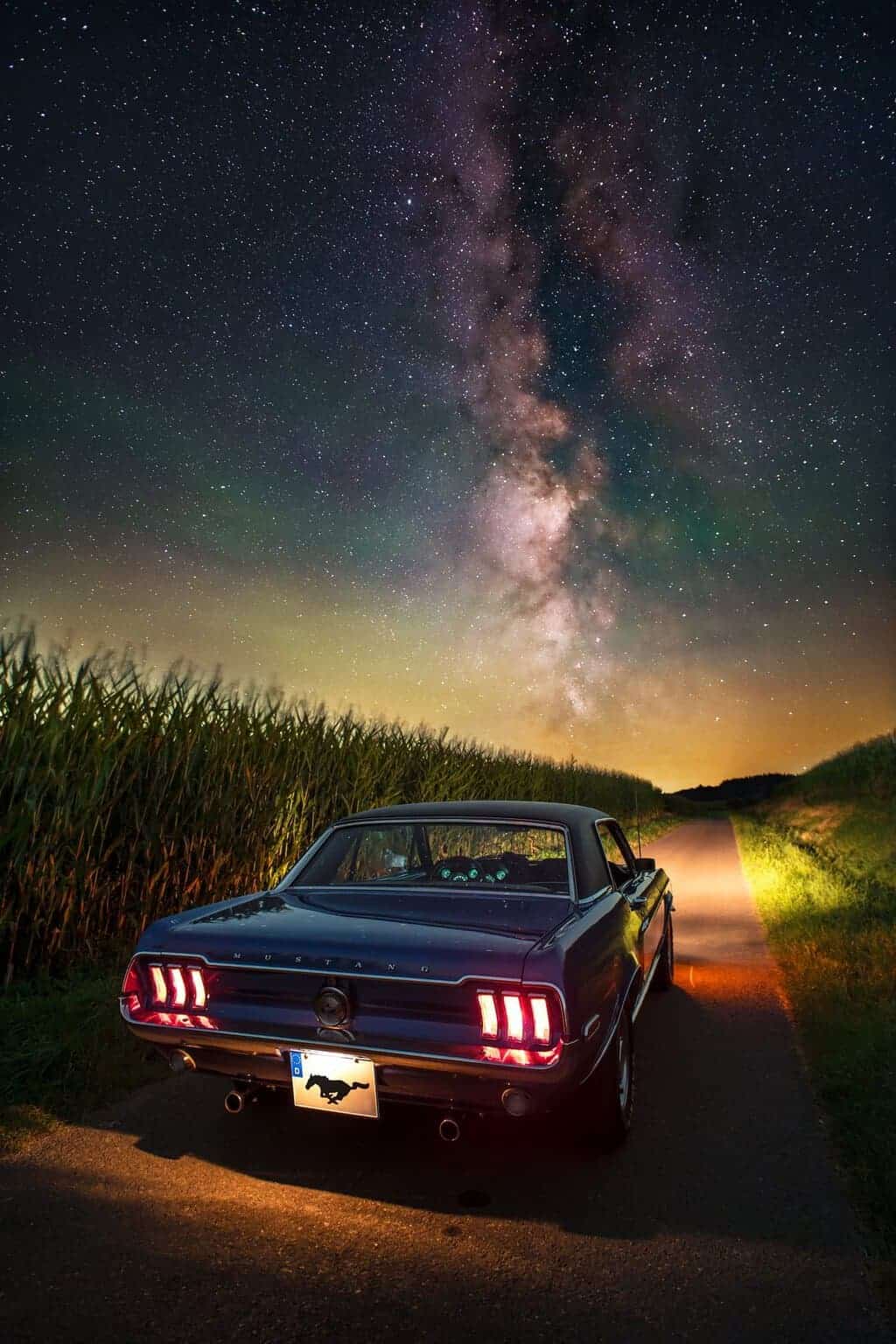 Classic Ford Mustang on a country road under the Milky Way by Evgeni Tcherkasski